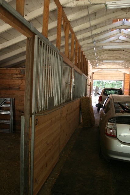 Inside horse barn and parked cars